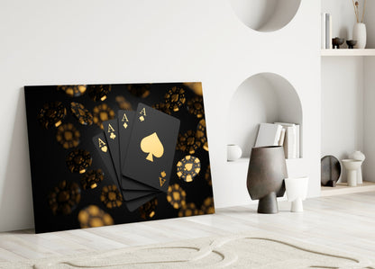 Black glass wall art with gold playing cards and casino chips leaning against white interior wall shelving.