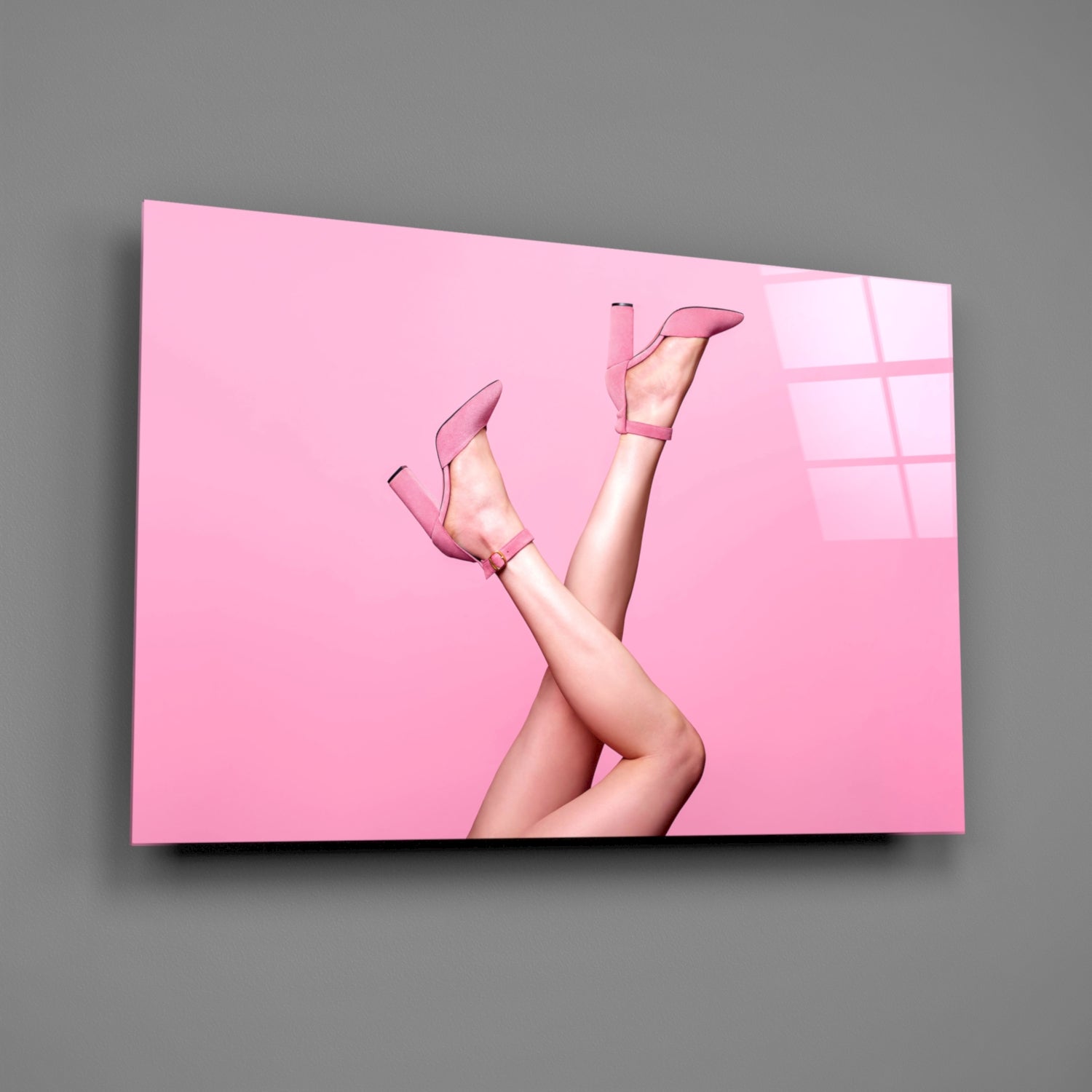 Pink glass wall art displaying a woman's legs in pink heels against a monochromatic pink background with window shadows.