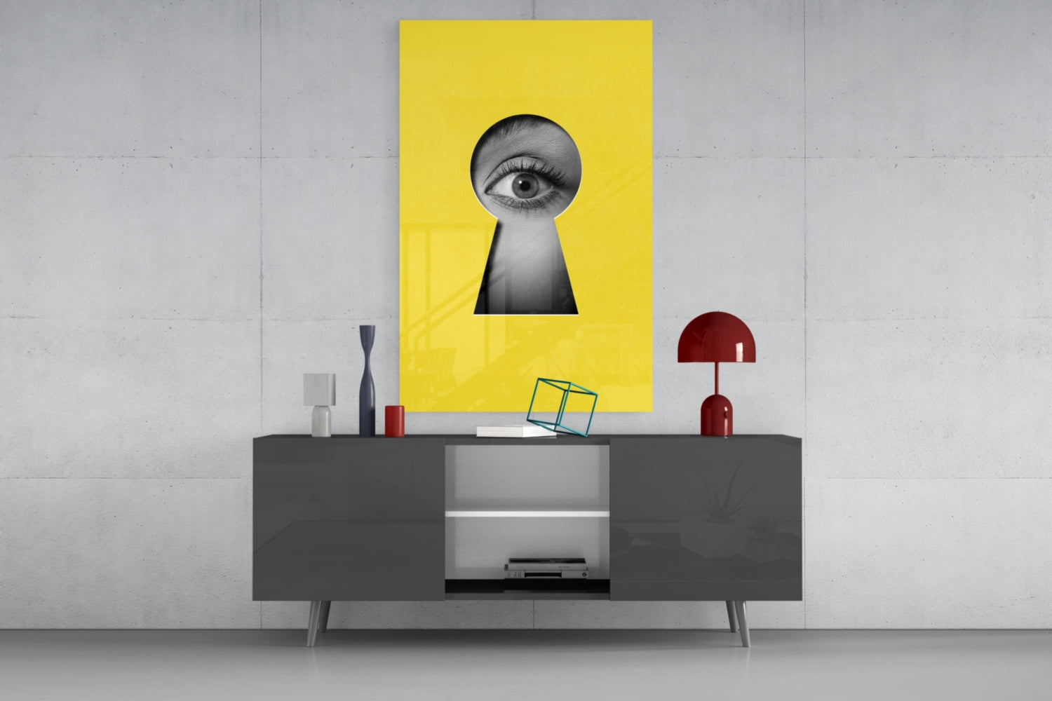 Yellow glass wall art with black and white eye peering through keyhole shape, displayed above gray media console.