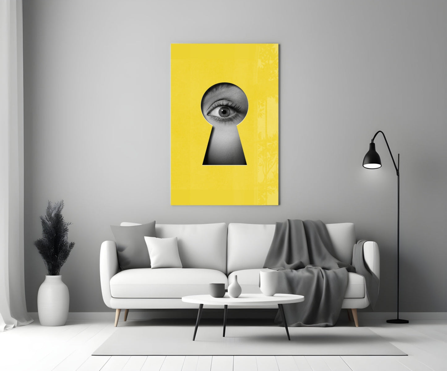 Yellow glass wall art with black keyhole cutout and eye illustration, displayed above white sofa in modern living room.