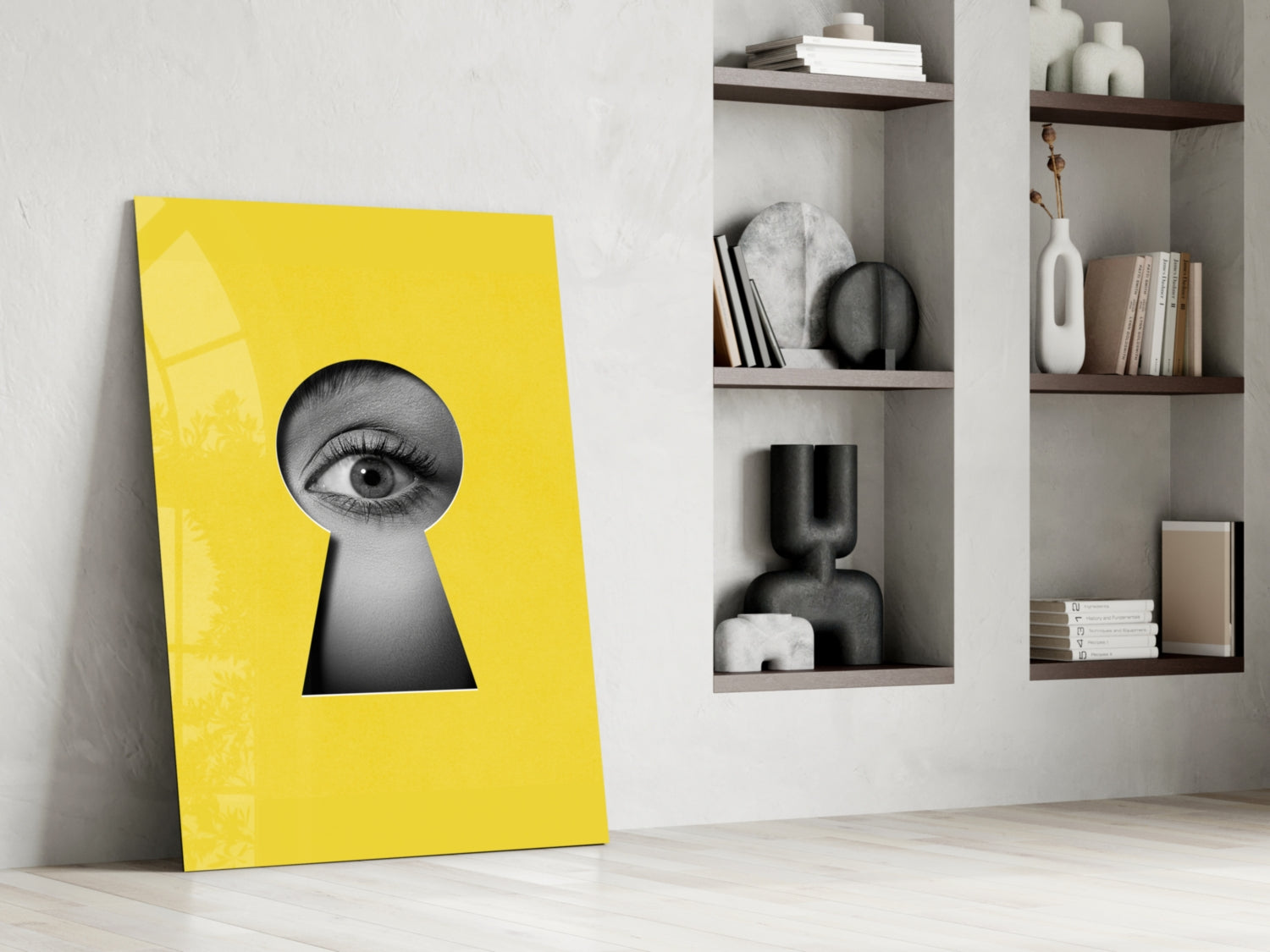 Bright yellow glass wall art leaning against white wall, featuring black and white eye illustration in keyhole shape.