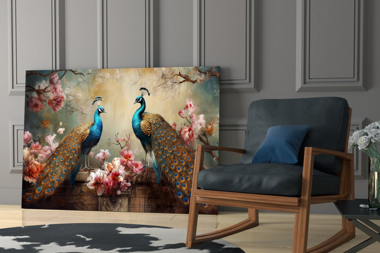 Peacock glass wall art displaying two blue peacocks with gold plumage among pink flowers, displayed in a modern room beside a wooden chair.