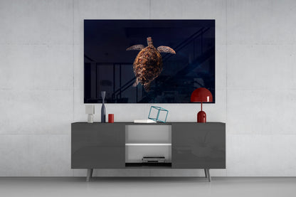 Tortoise glass wall art displayed on TV mounted above gray media console with red lamp and decorative accessories in modern living room setting.