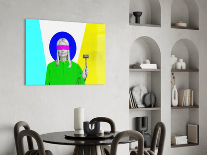 Colorful glass wall art depicting a figure in green jacket with pink blindfold and blue circular background displayed above round dining table.
