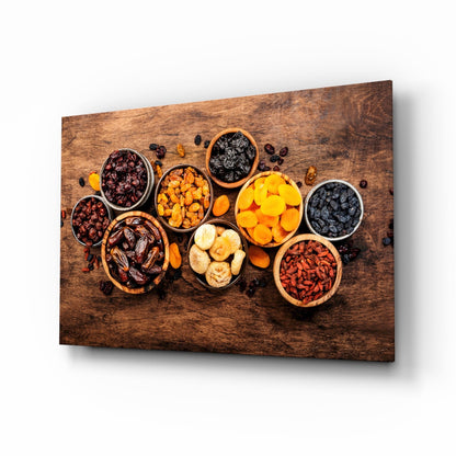 Angled perspective of wooden wall art displaying various dried fruits and nuts in ceramic bowls arranged on a textured brown wood surface.