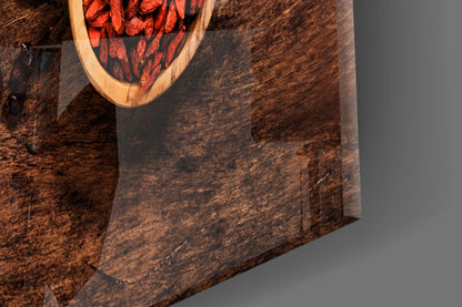 Overhead view of wooden wall art with red goji berries in oval bowl on textured brown background.
