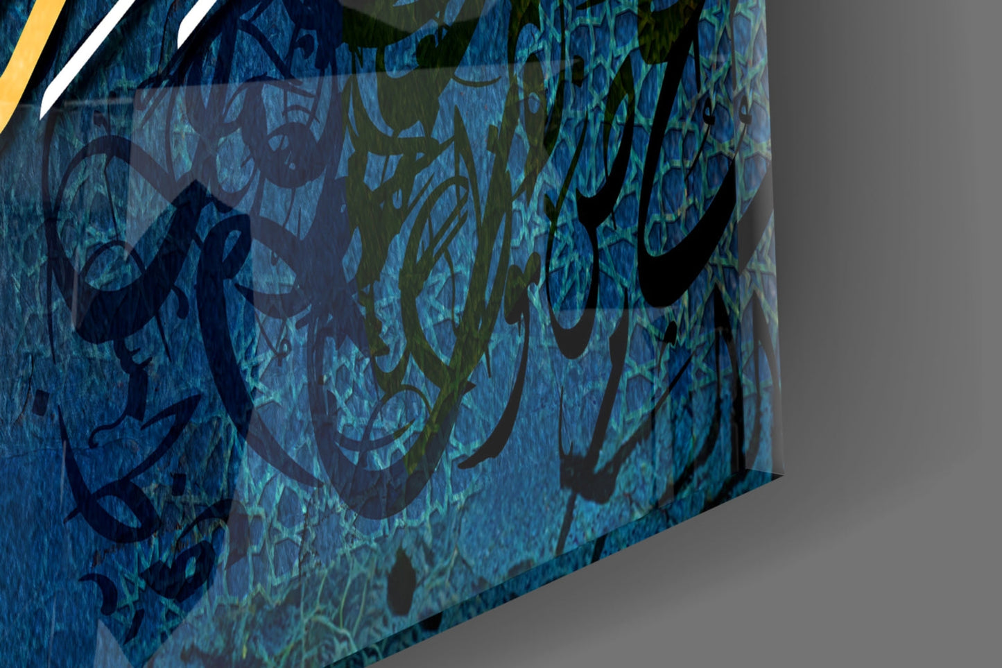Angled perspective of blue glass wall art with layered Islamic calligraphy and geometric patterns, showing depth and texture with yellow and white accent lines.