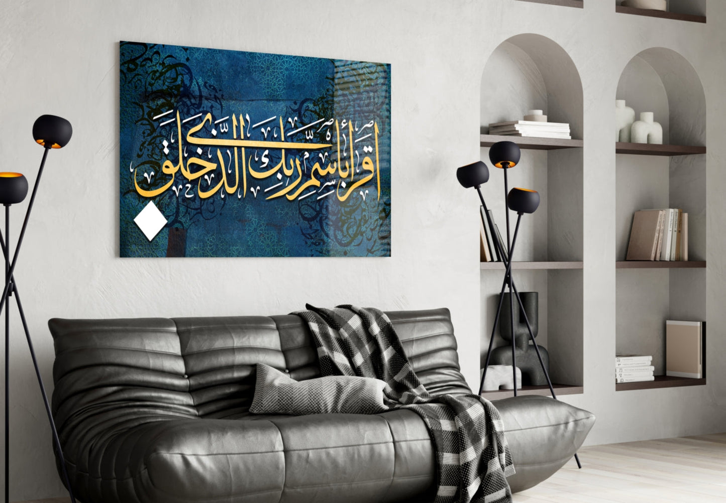 Modern living room interior with black leather sofa displaying blue glass wall art featuring gold Arabic calligraphy and decorative patterns.