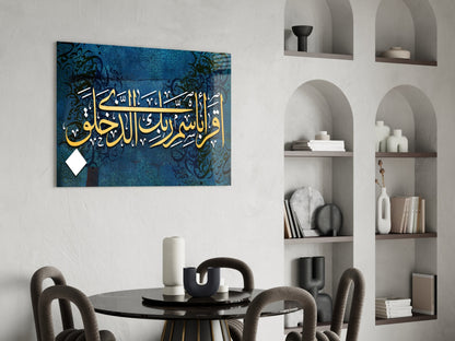 Blue glass wall art with white and gold Arabic calligraphy mounted above a black round dining table with gray chairs in a modern interior with built-in shelving.