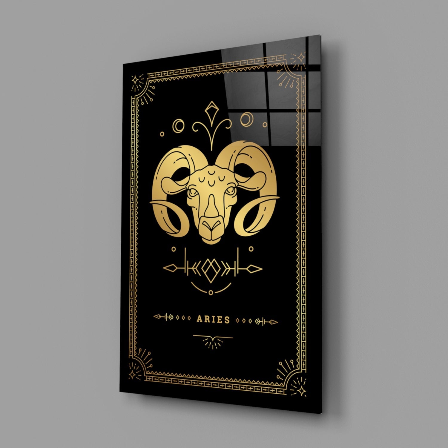 Black glass wall art with gold Aries ram illustration and decorative border, displayed at an angle showing depth and reflection.