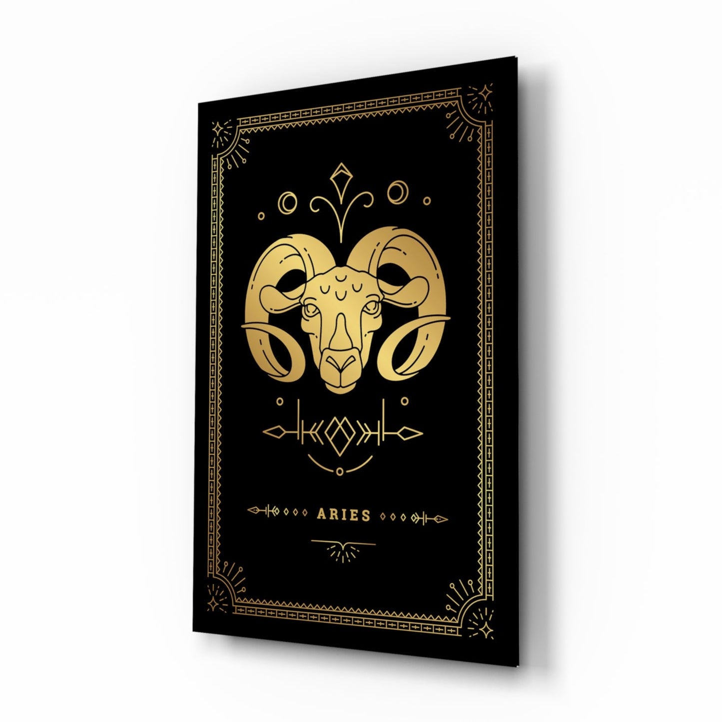 Black glass wall art panel with gold ram head design and "ARIES" text, displayed at an angle showing depth and shadow.
