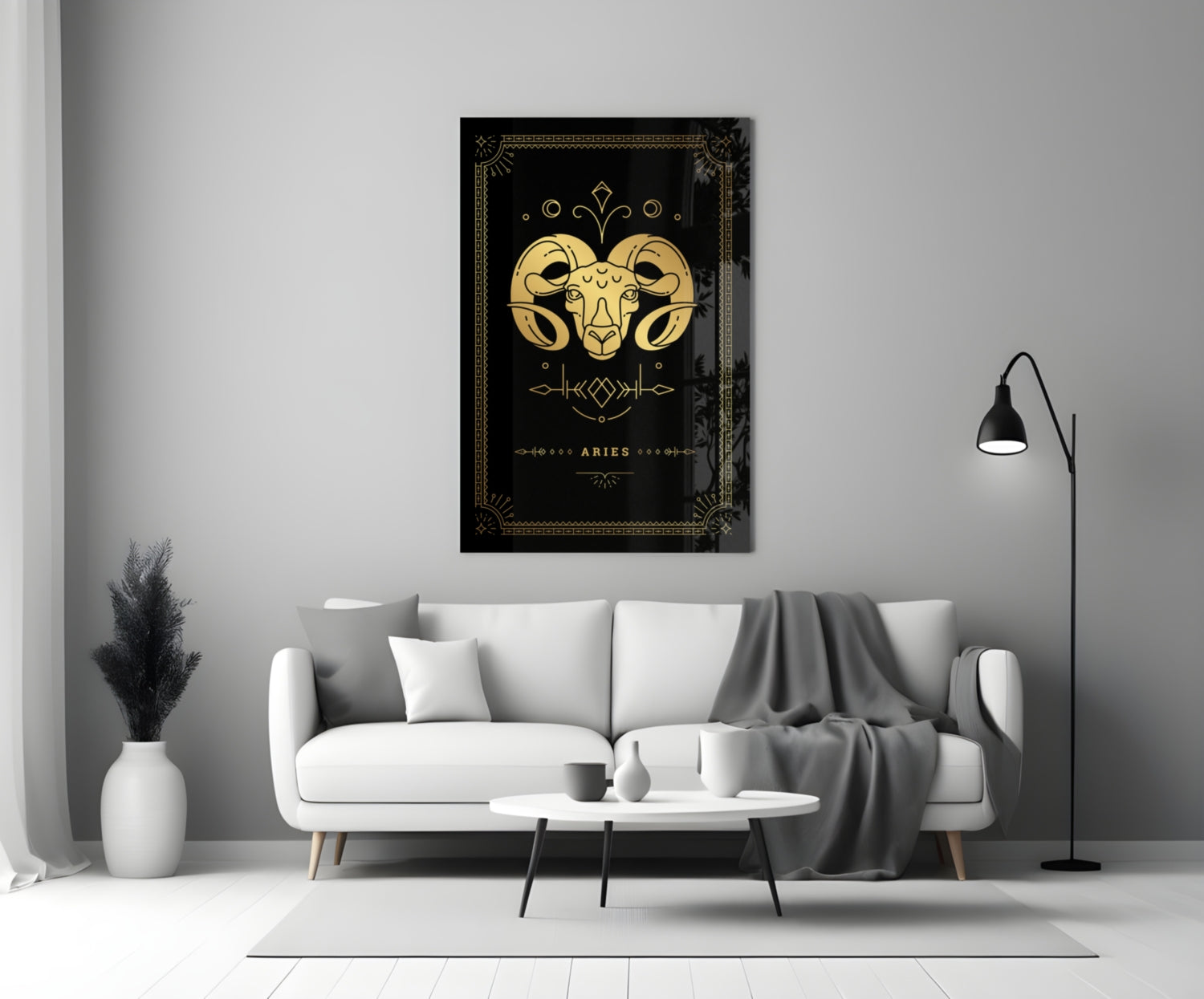 Black and gold Aries zodiac glass wall art with decorative border displayed above white sofa in minimalist living room.