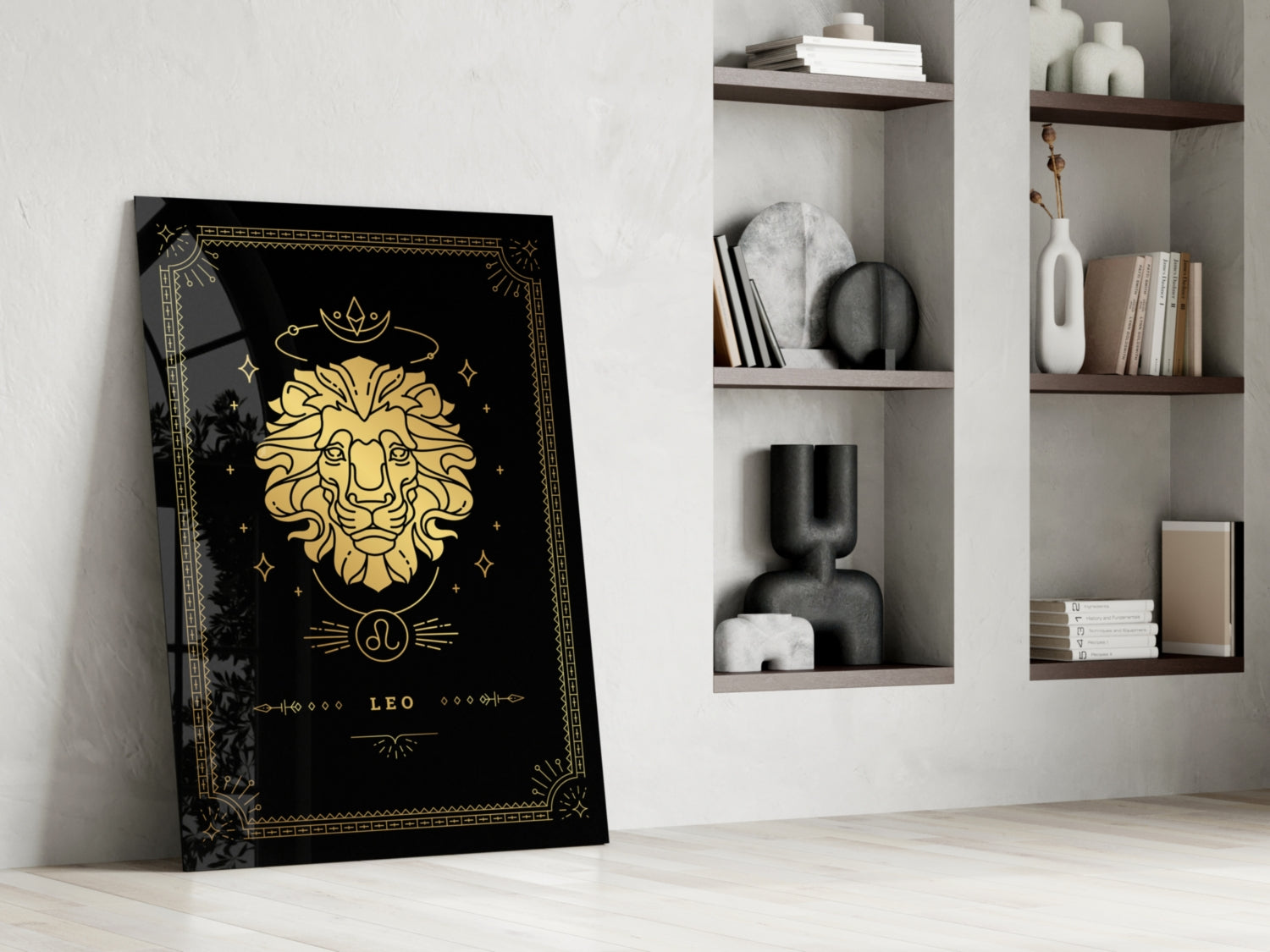Black glass panel with gold Leo zodiac lion illustration and decorative border leaning against white wall beside shelving.