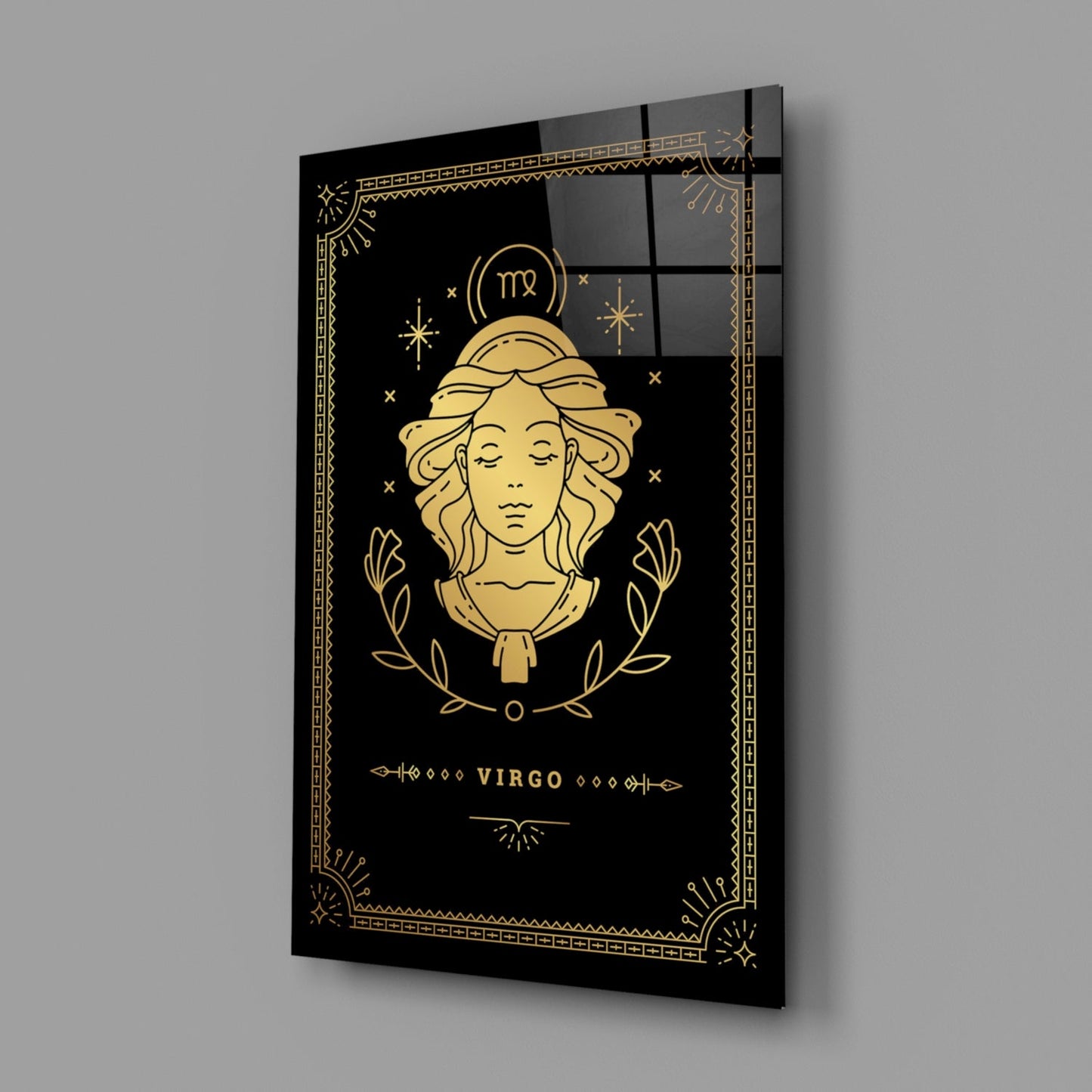 Angled perspective of black glass Virgo zodiac wall art with gold line illustration of female face, laurel wreath, and decorative border.