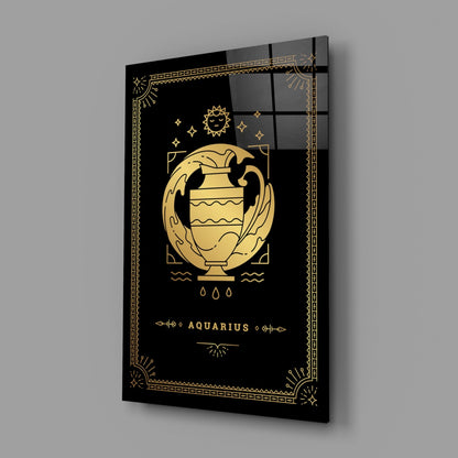 Black glass wall panel with gold Aquarius zodiac symbol, urn illustration, sun, stars, and decorative geometric border, angled perspective view.