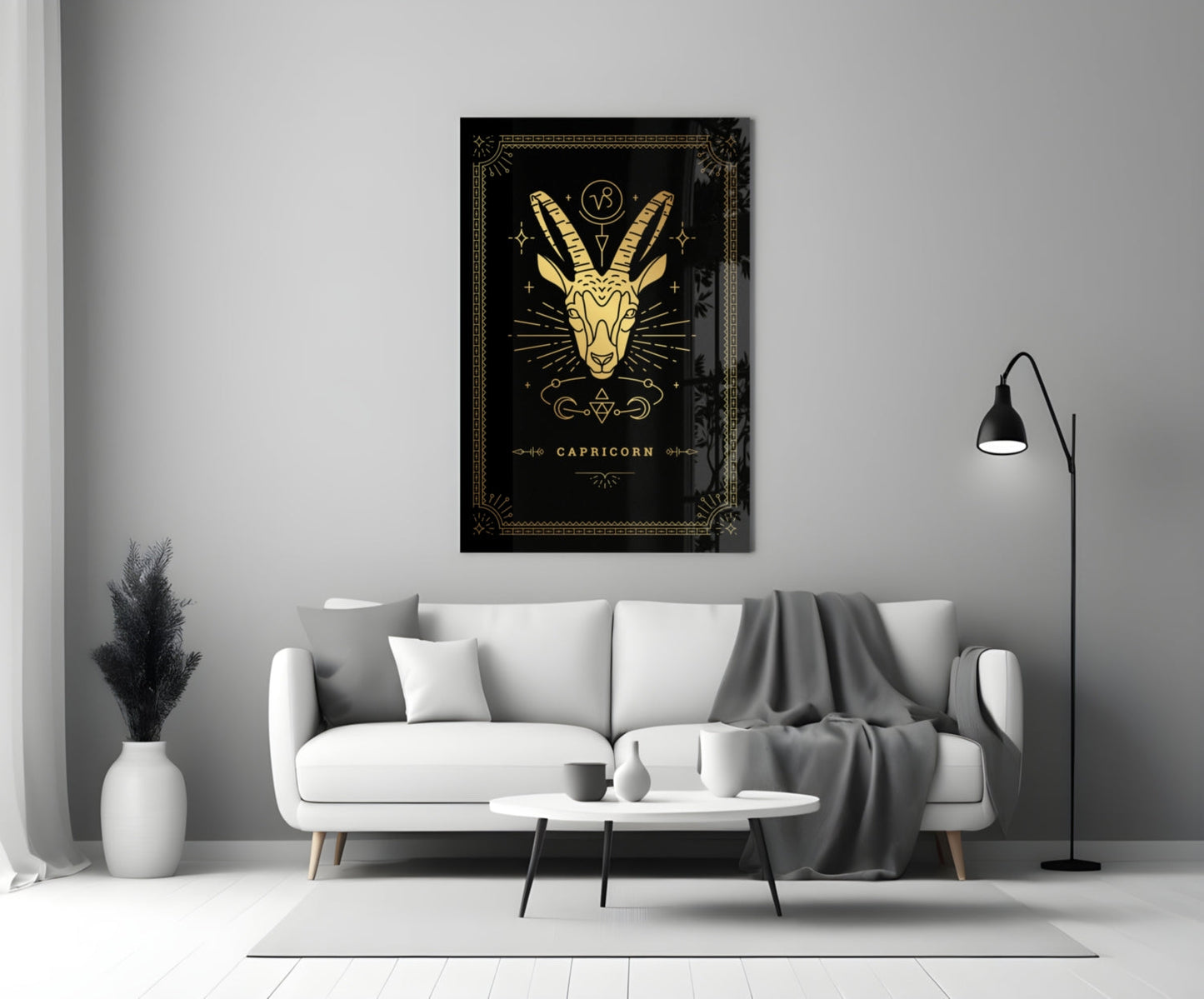 Capricorn glass wall art with gold goat illustration on black background displayed above white sofa in modern living room.