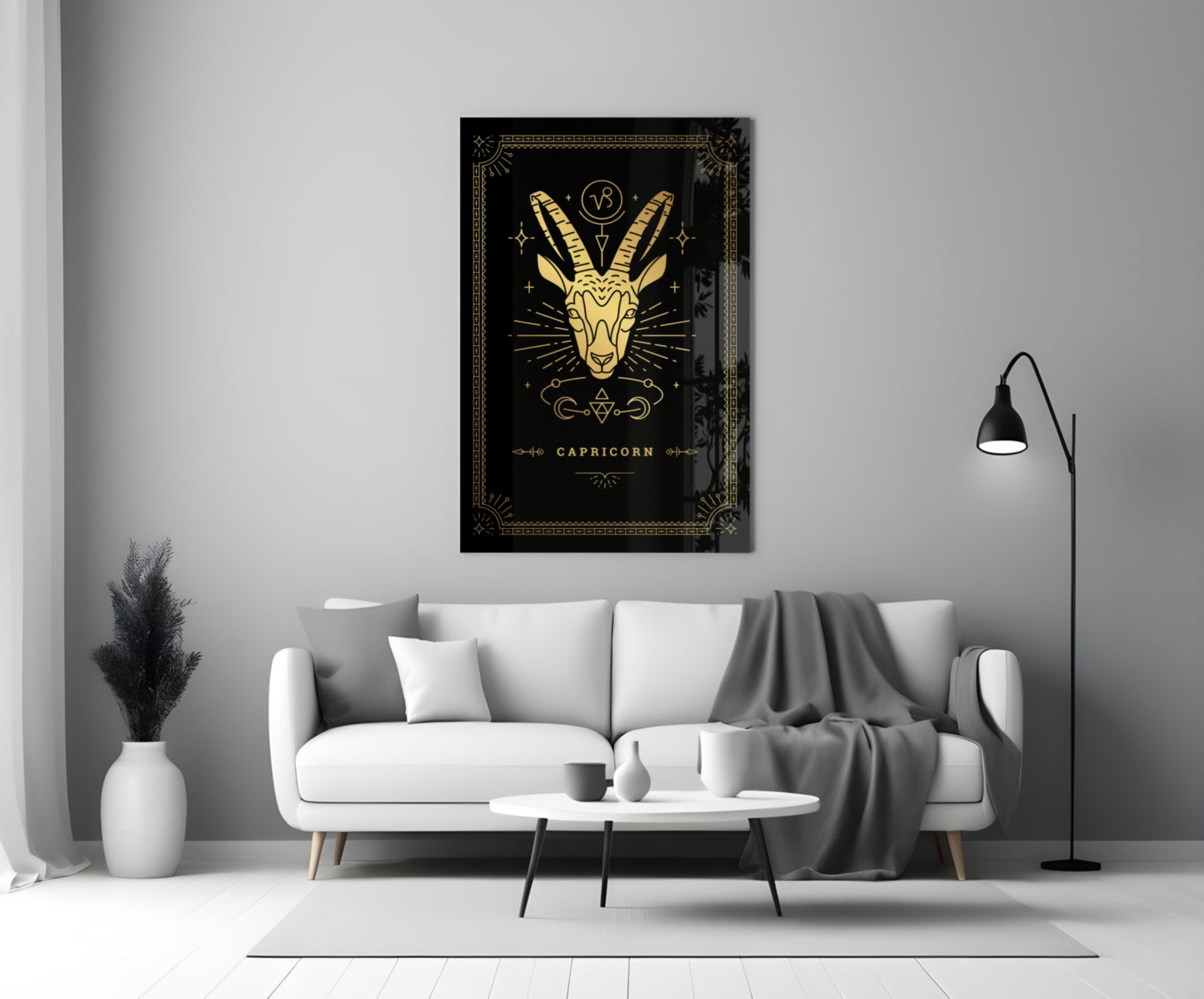 Capricorn glass wall art with gold goat illustration on black background displayed above white sofa in modern living room.