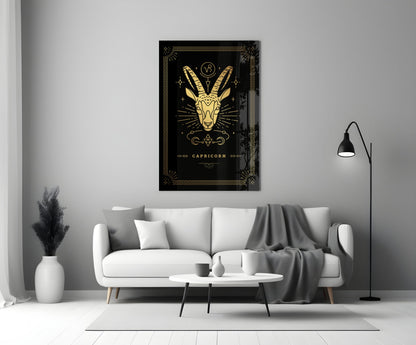 Capricorn glass wall art with gold goat illustration on black background displayed above white sofa in modern living room.