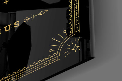 Black glass wall art with gold etched Sagittarius zodiac symbol, arrows, and decorative geometric patterns, displayed at an angle.