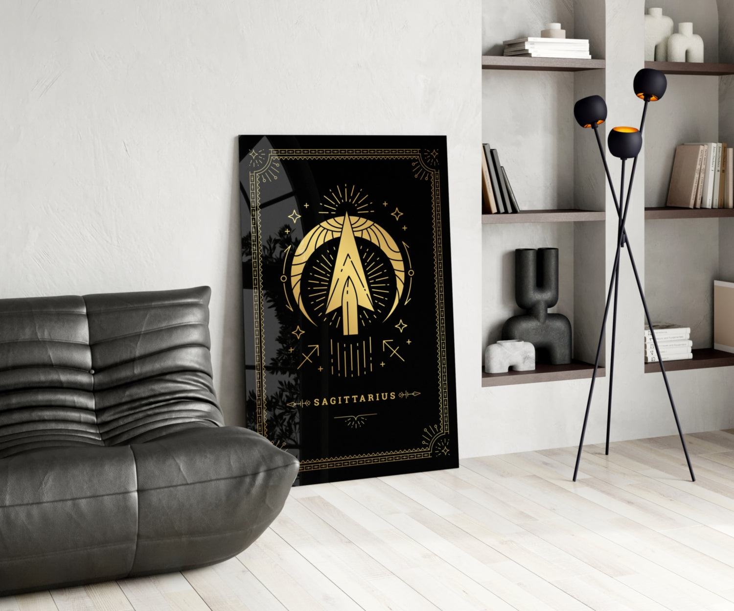 Black glass Sagittarius zodiac wall art with gold celestial design displayed in modern living room beside gray leather chair and shelving unit.