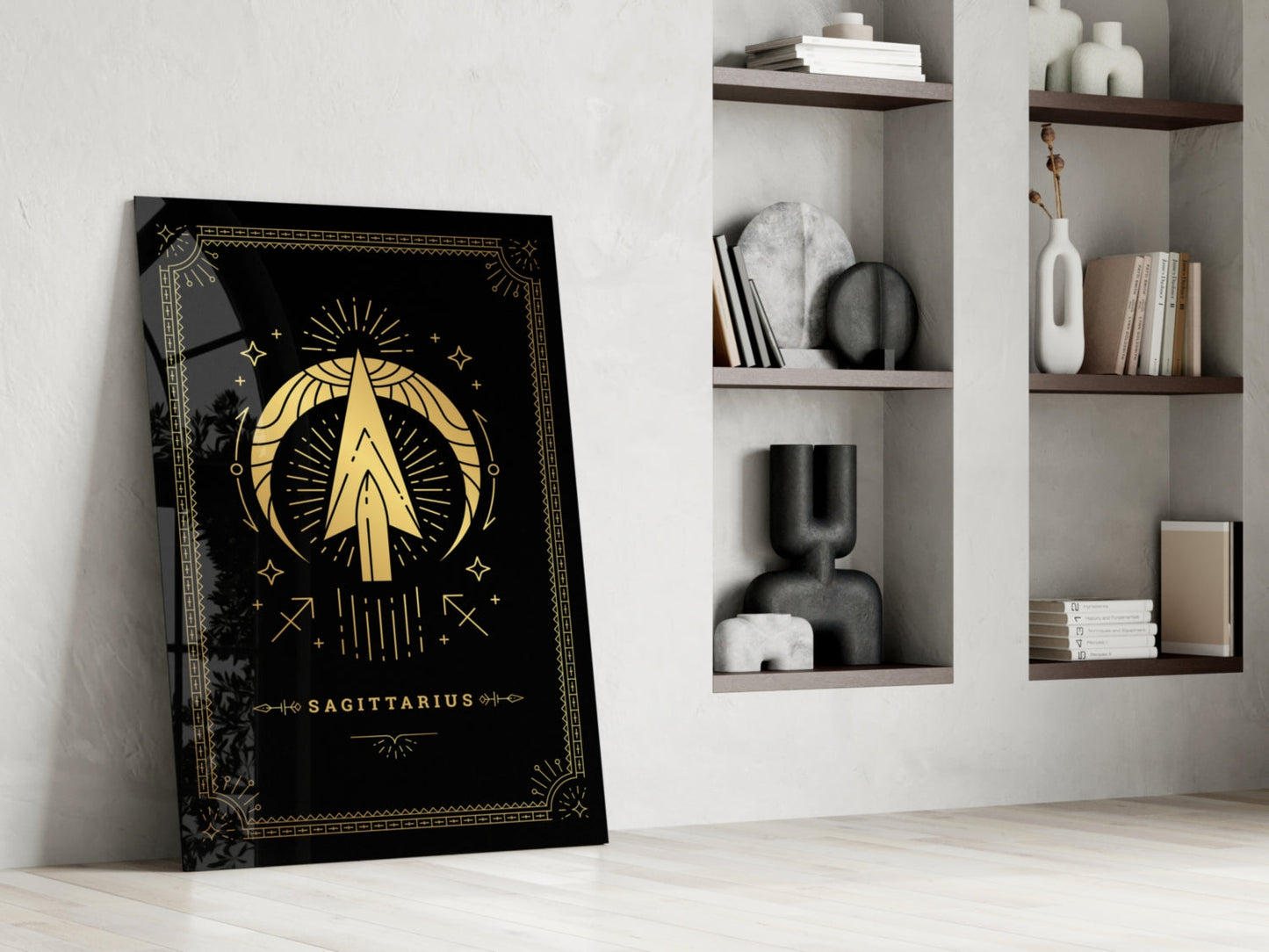 Black glass Sagittarius tarot card art leaning against white wall beside wooden shelving with decorative objects and books.