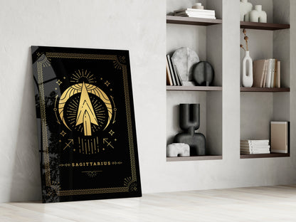 Black glass Sagittarius tarot card art leaning against white wall beside wooden shelving with decorative objects and books.