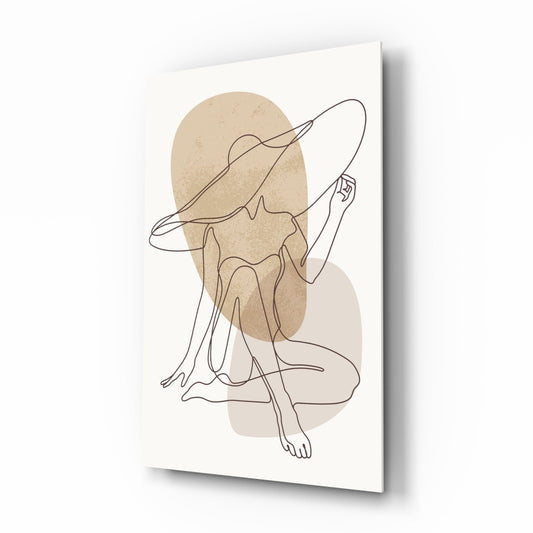 Angled view of glass wall art featuring a continuous line drawing of a seated woman in a hat, with beige and taupe watercolor shapes on cream background.