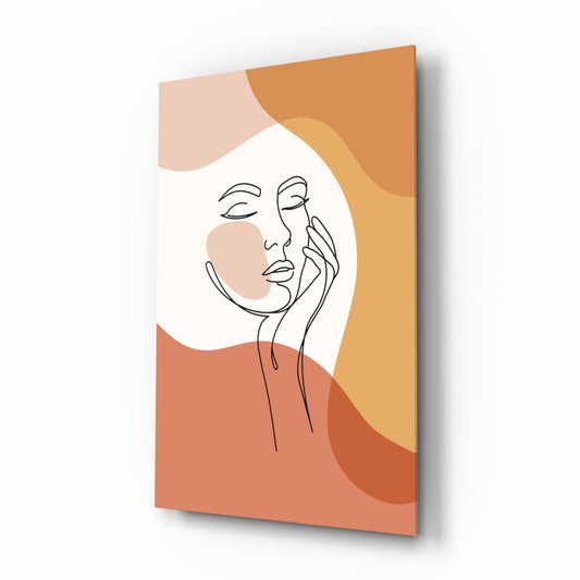 Angled view of a glass wall art panel featuring a minimalist line-drawn face with hand on cheek, set against warm terracotta, orange, and cream abstract shapes.