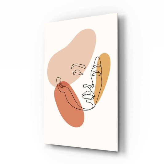 Angled view of a glass wall art panel displaying an abstract line-drawn face with beige, coral, and golden organic shapes on cream background.