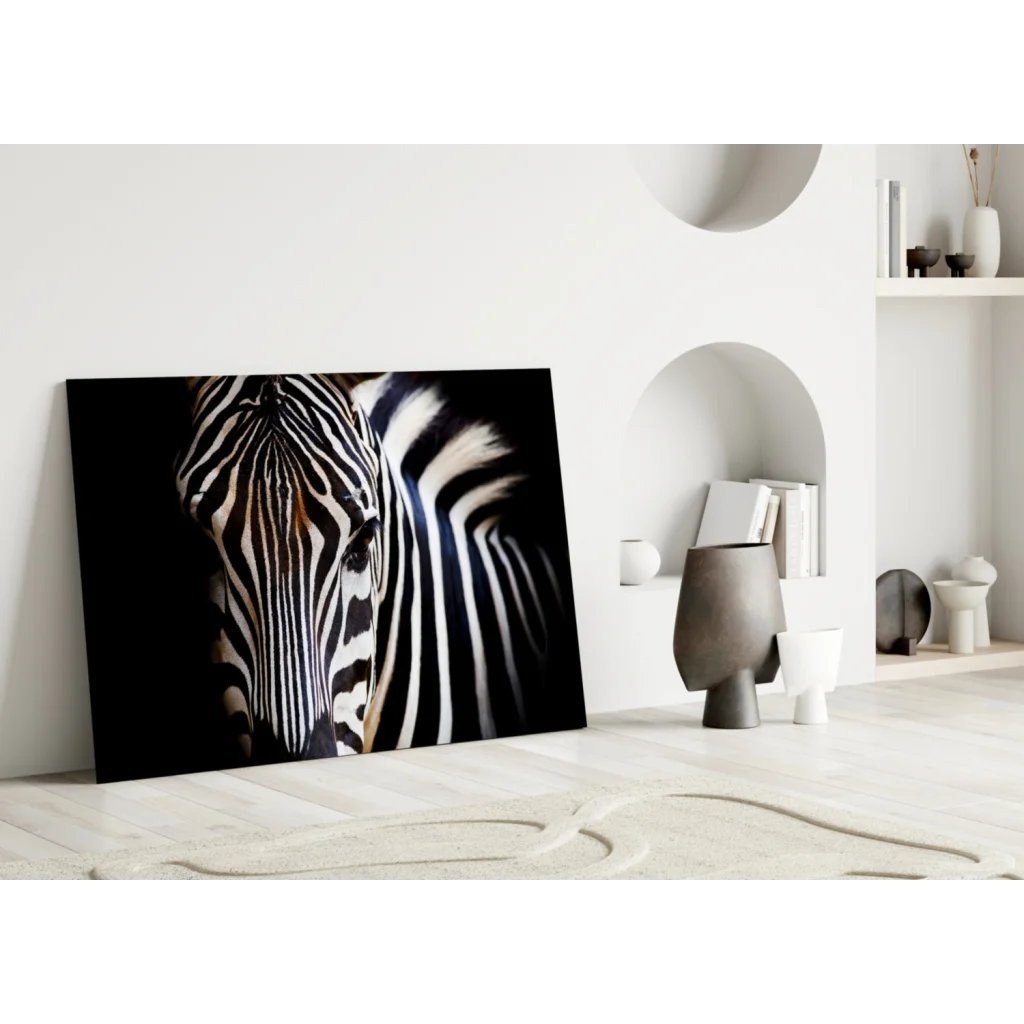 Black-and-white zebra portrait on tempered glass art leaning against white wall